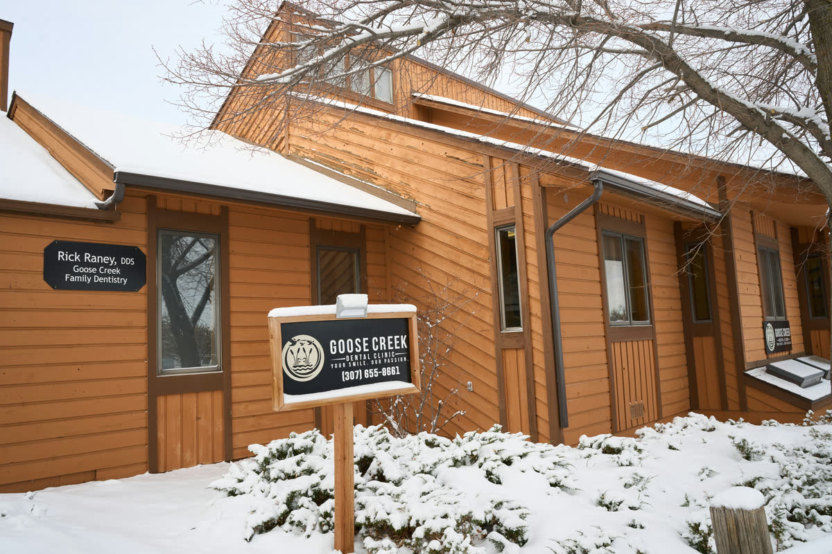 The side of the Goose Creek Dental Clinic building in snow, with Dr. Rick Raney's name beside the door.