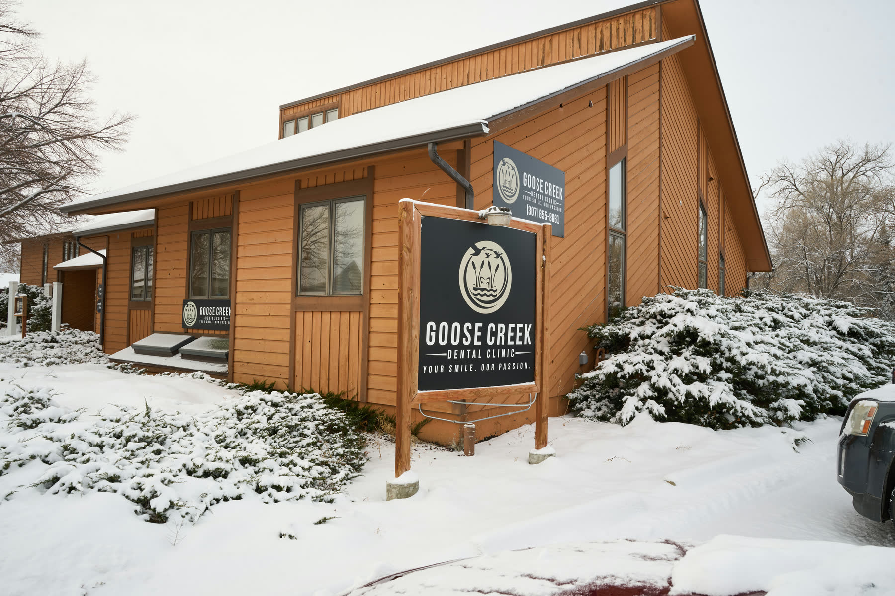 The Goose Creek Dental Clinic building on Val Vista Street after a snowfall, its sign at the walk.